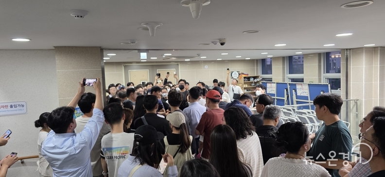 행정복지센터 3층 다목적실 앞에서 시행사 측과 대치하고 있는 주민들